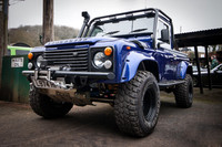 A lifted, blue, Land Rover Defender Pickup, Reg: L974HFV